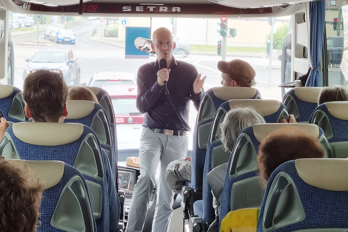 Mann spricht im Bus in ein Mikrophon